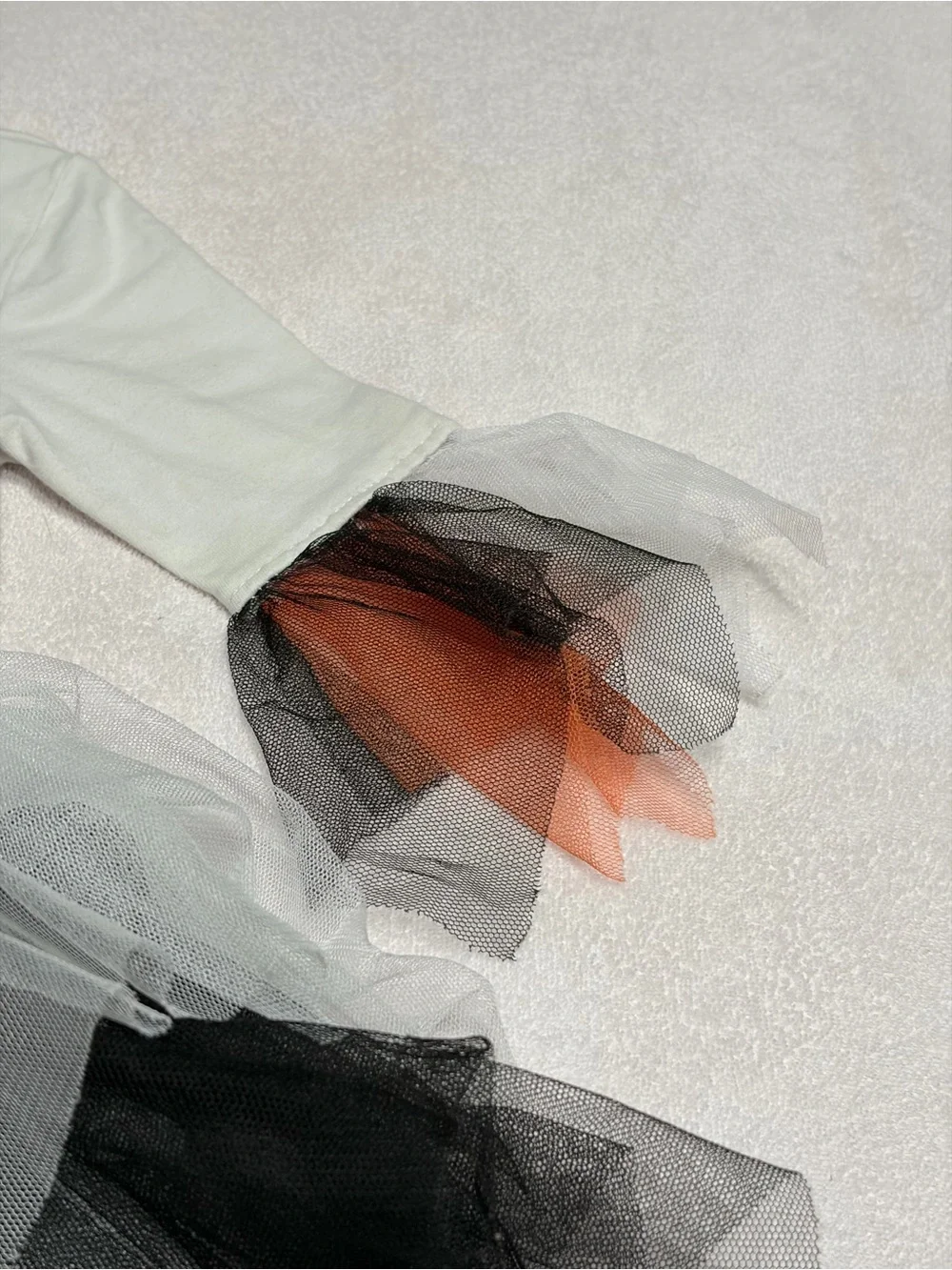 Cutie Halloween costume Has orange, black, and white tulle skirt and wrists.